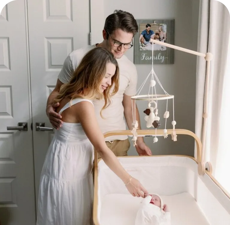 Parents standing beside a Cradlewise crib