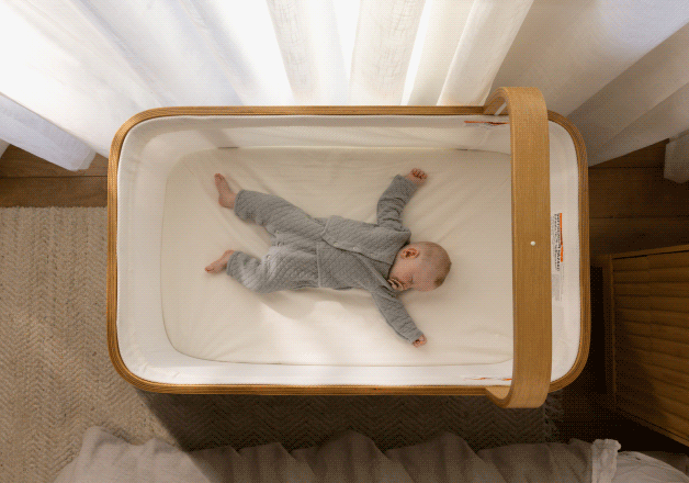 Baby resting in the Cradlewise crib while a soundtrack plays